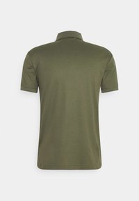 Olivgrön polo skjorta med korta ärmar, ribbad krage och en slät yta. Bakifrån visas rena linjer och en skräddarsydd passform.