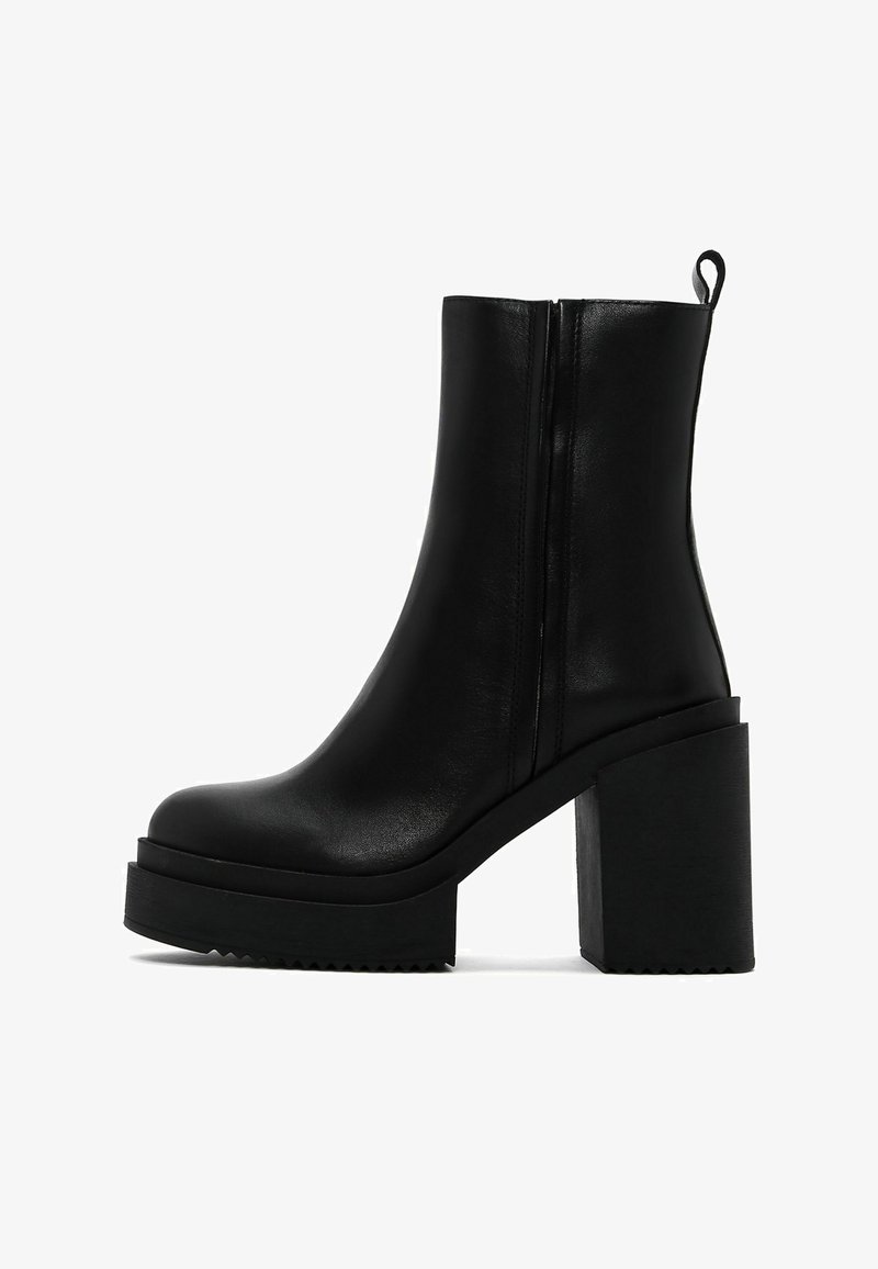 Black leather ankle boot with a rounded toe, side zipper, and chunky block heel. Features a platform sole with a textured edge.