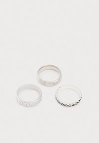 Kolm hõbedast sõrmust. Ühel on geomeetriline muster, teisel on sile pind ja kolmandal on tekstuuriga laineline disain.