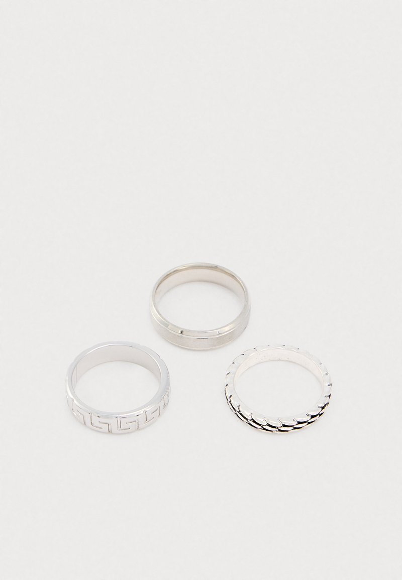 Kolm hõbedast sõrmust. Ühel on geomeetriline muster, teisel on sile pind ja kolmandal on tekstuuriga laineline disain.