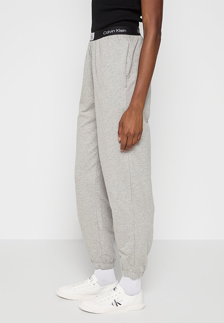 Pantaloni jogger grigi con una cintura elastica che presenta un logo Calvin Klein, con polsini svasati, realizzati in un morbido tessuto misto cotone.