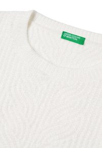 Maglione bianco con texture e scollo a girocollo, caratterizzato da un sottile motivo a treccia e un'etichetta verde che mostra "UNITED COLORS OF BENETTON."