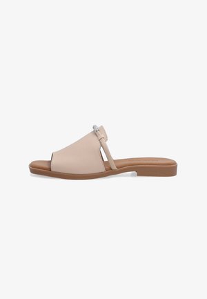 Beige læder slid sandal med en bred forreste rem, åben tå, slank side rem og en dekorativ sølvaccent. Flad brun sål.