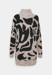 Pullover in beige chiaro e leggermente peloso con motivi astratti neri, colletto alto e maniche lunghe, caratterizzato da una morbida texture e orlo arrotondato.