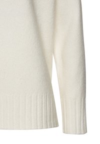 Cremfarbener Strickpullover mit weichem Material, geripptem Saum und weiten Ärmeln für eine lockere Passform. Der Stoff wirkt leicht und warm.