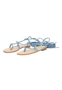 Sandali piatti di un blu chiaro con un design minimalista, dotati di morbide cinghie in tessuto e una suola piatta color cuoio. I lacci avvolgono la caviglia.