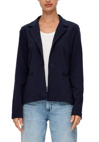 Granatowa marynarka wykonana z miękkiego materiału, z kołnierzykiem, zapięciem na jeden guzik oraz dwiema przednimi kieszeniami. Krótki fason z luźnym krojem.