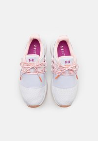 White athletic shoes with a textured upper, pink lace accents, and purple inner lining. Features elastic laces and a cushioned sole.