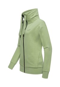 Felpa con zip verde chiaro, colletto alto, cerniera nera e dettagli in nero, realizzata in materiale morbido, con polsini a coste e tasche laterali.