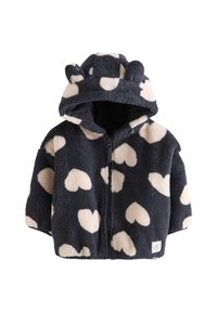 Veste en polaire bleue marine avec des motifs de cœurs crème, capuche avec oreilles d'ours, fermeture éclair à l'avant et texture douce. Comprend une petite étiquette logo à l'ourlet.