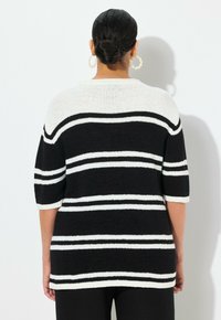 Gestreifter Strickpullover in Schwarz-Weiß mit kurzen Ärmeln, weitem Ausschnitt und lässiger Passform. Weiche Textur und ausgeprägtes Musterdetail.