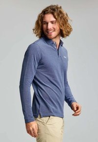 Langarm-Polo in Marineblau, aus weichem Baumwollmix. Mit Kragen, einer dreiknöpfigen Knopfleiste und seitlichen Schlitzen für zusätzlichen Komfort.