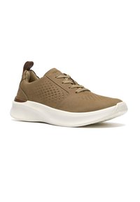 Zapatilla deportiva casual marrón con lados perforados, cierre de cordones, cuello acolchado y suela blanca gruesa, vista en ángulo para mostrar el lado exterior.