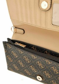 Portefeuille texturé noir avec un motif monogramme, intérieur beige, compartiment zippé et fermeture à pression avec quincaillerie argentée.