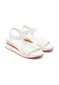 Sandalias blancas con una correa trenzada, correa de tobillo ajustable y una suela contorneada. Acabado suave y suela de color claro con un diseño sutil.