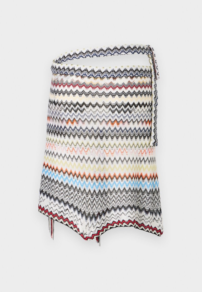 Jupe bandeau en maille à motif zigzag multicolore, avec un ourlet en pointe et un détail noué, sur un fond uni.