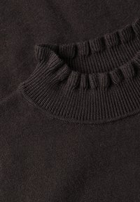 Gros plan sur l'encolure d'un pull tricoté brun foncé avec un détail de col côtelé et froncé.