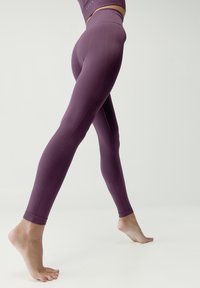 Fioletowe rajstopy bezszwowe z teksturowanymi panelami i wysokim paskiem, o dopasowanym kroju i długości do kostek.
