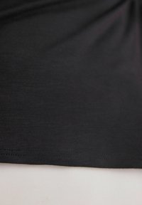 Zwarte shirt met korte mouwen met een soepele textuur en een rechte zoom. De stof heeft een lichte glans en is lichtgewicht.