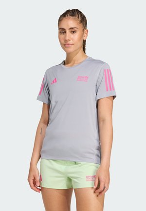 Grijze sportt-shirt met roze accenten en logo, gecombineerd met lichtgroene shorts met roze tekst. Gemaakt van vochtabsorberende stof.