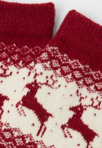 Rød og creme-mønstret strikkede sokker med hjorte motiver, med en tekstureret finish og en ribbet kant for ekstra varme.