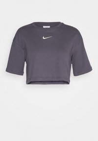 Zkrácený šedý tričko vyrobený z bavlny, s krátkými rukávy a kulatým výstřihem. Bílé logo Nike je umístěno ve středu hrudi.