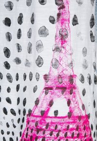 Esquisse de la Tour Eiffel rose avec des pois noirs irréguliers sur un fond de tissu blanc.