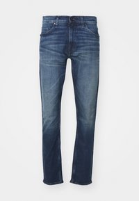 Mörkblå denimjeans med rak bendesign, blekta områden, fem fickor och dragkedja med knappstängning. Klassiska sömnadsdetaljer.