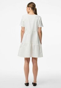 Vit bomullsklänning med korta ärmar, i lagerdesign och en slät textur, med en avslappnad passform som når till med låren.
