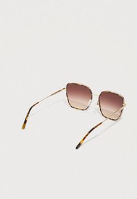 Sluneční brýle s želvovinovým vzorem, čtvercovými obroučkami, hnědými gradientními čočkami a tenkými zlatými kovovými prvky na stranách a mostu přes nos.