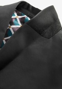 Schwarze Jacke mit glatter Textur, ausgestattet mit einem kontrastierenden Kragen und einem bunten geometrischen Musterfutter, das am Kragen sichtbar ist.