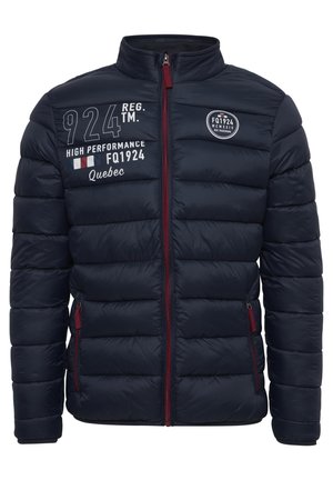 Nabijenijak jakna tamnoplave boje s visokim ovratnikom, prednjim patentnim zatvaračem i crvenim detaljima. Ima bijeli tekst i logotipe na prsima i lijevoj ruci.