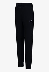 Čierne tepláky vyrobené z mäkkej látky, s elastickým pásom, manžetami na členkoch a bielym logom Jordan na ľavom stehne.