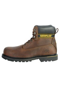 Stivale da lavoro in pelle marrone con punta in acciaio, colletto imbottito nero, dettagli del logo giallo e suola in gomma robusta con battistrada pronunciato.