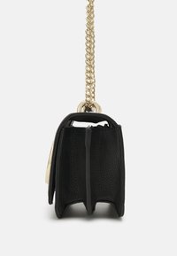 Svart syntetisk handväska med en texturerad yta, gyllene kedjestropp och en strukturerad form med en platt botten och en öppen topp.