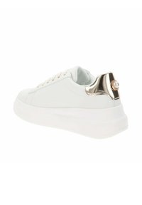 Baskets blanches avec une tige en cuir lisse, bout arrondi et accent doré métallique au niveau du talon, présentant un détail décoratif en perles.