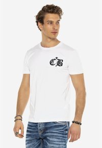 Weißes Baumwoll-T-Shirt mit kurzen Ärmeln, ausgestattet mit einem schwarzen Logo-Taschenaufdruck mit "CB" und einem Stern. Der Schnitt ist lässig mit einem runden Halsausschnitt.
