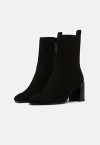 Czarne zamszowe botki za kostkę na słupku, o smukłym fasonie, z zamkniętym noskiem, bocznym zamkiem błyskawicznym i pętelką z tyłu.