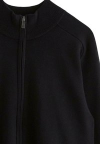 Schwarzer Reißverschluss-Pullover mit geripptem Kragen und Schulternähten, der über eine glatte Textur und ein minimalistisches Design verfügt. Keine sichtbaren Muster oder Akzente.