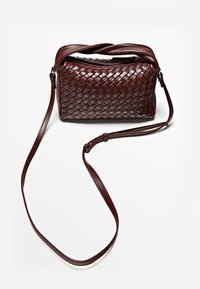 Borsa a tracolla intrecciata in pelle di colore bordeaux scuro con chiusura a cerniera, tracolla regolabile e texture liscia. Forma rettangolare compatta.