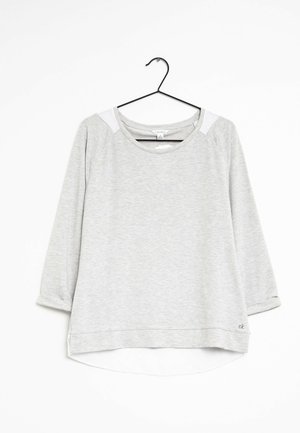 Harmaa pitkähihainen paita, jossa on pyöreä kaula-aukko, kolmanneksia hihat ja kontrastivalkoiset hartiahupat. Pehmeä, tekstuurinen kangas, hieman kaareva helma.