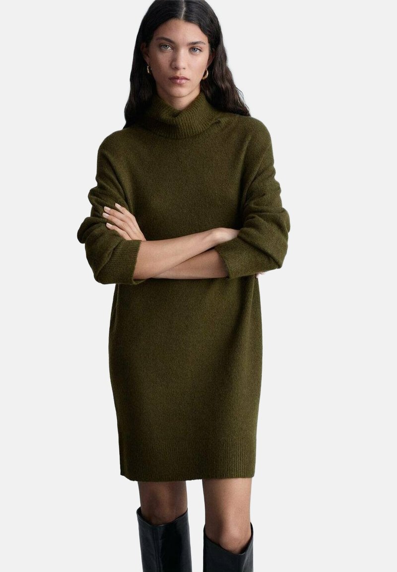 Abito maglione in verde oliva scuro, con colletto alto, maniche lunghe e taglio rilassato, che si estende fino a metà coscia.