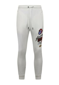 Witte joggingsbroek van katoen, met een trekkoord in de taille en grafische prints, waaronder logo's en tekst, op het linkerpijp.