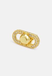 Spilla dorata con design ovale, caratterizzata da un bottone centrale circolare e circondata da strass trasparenti. Marcata con il marchio "MK".