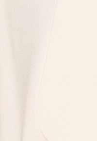 Tela de color crema con una textura suave, que presenta una superficie lisa y un detalle de bolsillo. El material parece ligero y ligeramente reflectante.