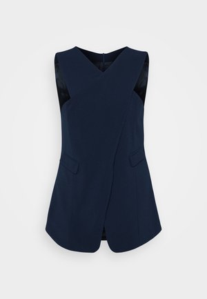 Navy sleeveless top with a diagonal wrap design, featuring side pockets and smooth texture, designed for a structured silhouette.