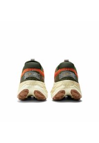 Un par de zapatillas verdes y naranjas con suelas beige gruesas, mostradas desde atrás sobre un fondo blanco.