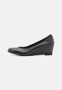 Escarpin en cuir noir à talon compensé, avec une pointe arrondie, une texture lisse et un talon compensé bas. Conception minimaliste avec un bord cousu subtil.