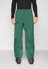 Žalios žieminės kelnės laisvo kirpimo, pagamintos iš vandeniui atsparios medžiagos. Ypatybės: du priekiniai mygtukai, šoninėje pusėje esanti kišenė su užtrauktuku ir patvarios siūlės.