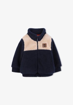 Navy and beige fleece zip-up jacket with high collar, ribbed cuffs, and a small brown patch logo on the chest.